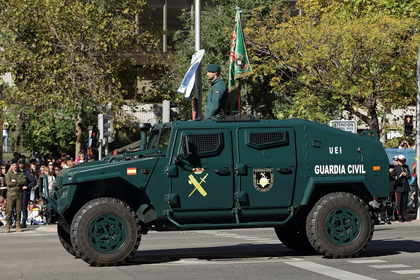 Vehículo blindado de la Guardia Civil con un agente y el guion de la unidad durante un desfile