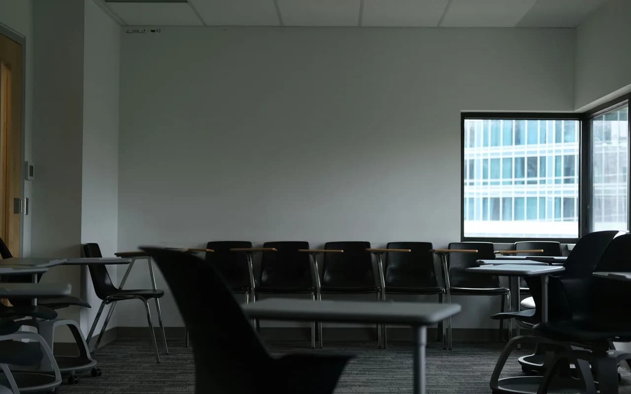 Aula universitaria moderna con pupitres y grandes ventanales