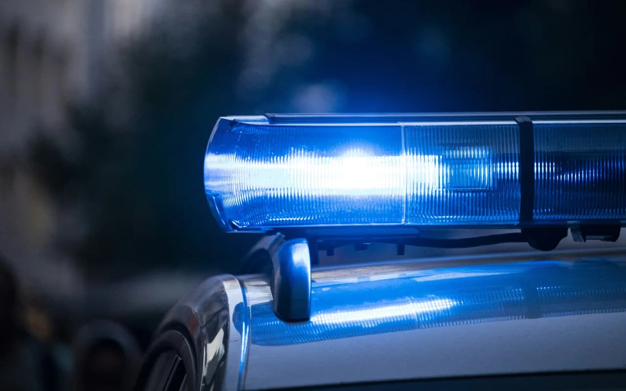 Detalle moderno de un rotativo azul encendido sobre un coche policial