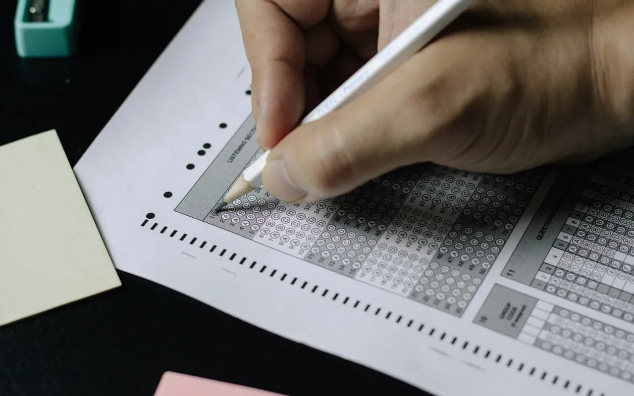 Persona escribiendo respuestas en una hoja de examen
